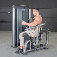 Thumbnail for Man using a gray rotary torso machine with black padding and yellow adjustment levers.