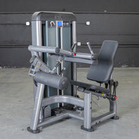 Thumbnail for Gray seated leg curl machine with black padding and red adjustment knobs.