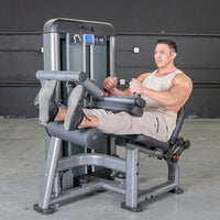 Thumbnail for Man using a seated leg curl machine, performing a leg curl exercise.