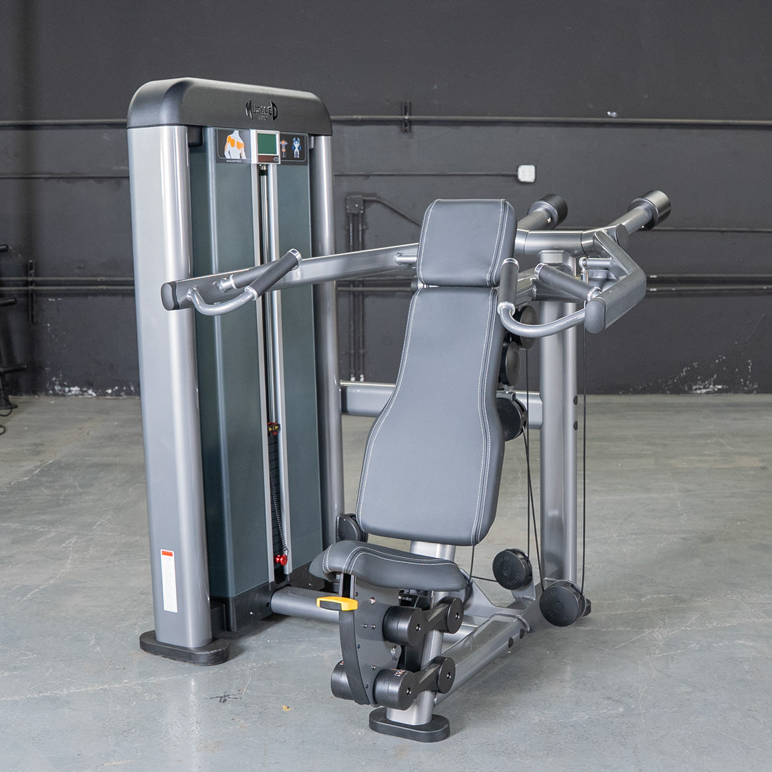 Gray shoulder press gym equipment with black padded seat and handles.