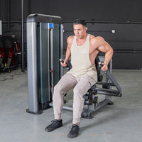 Thumbnail for Man in a tank top and sweatpants using a triceps press machine in a gym.
