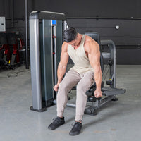 Thumbnail for Man in a tank top and sweatpants using a triceps press machine in a gym.