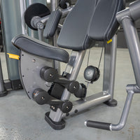 Thumbnail for Close-up of a gray biceps curl machine with black padded seats, yellow adjustment levers, and black handles.