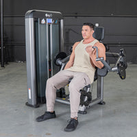 Thumbnail for Man in a tank top using a biceps curl machine in a gym.