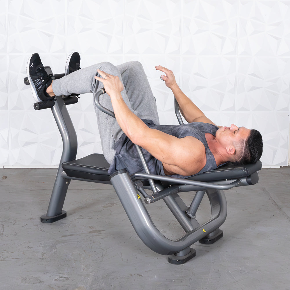 Man in gray tank top and sweatpants using a gray ab roller machine.