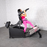 Thumbnail for Woman in pink using a black plate-loaded hack squat machine with weights.