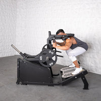 Thumbnail for Man performing a squat on a black plate-loaded hack squat machine with 45lb weights.
