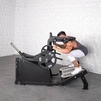 Thumbnail for Man performing a squat on a black plate-loaded hack squat machine with 45lb weights.