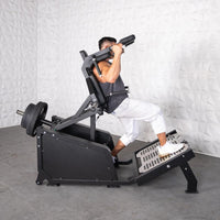 Thumbnail for Man performing a squat on a black plate-loaded hack squat machine with weights.