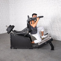 Thumbnail for Man using a black plate-loaded hack squat machine with weight plates on the back.