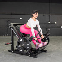Thumbnail for Woman in pink leggings using a black linear bearing row machine with 45lb weight plates.