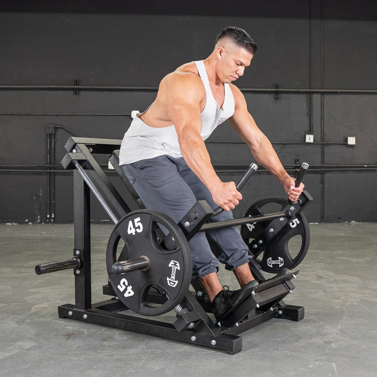 Man using a linear bearing row machine with weight plates in a gym.