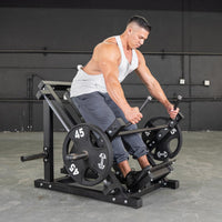 Thumbnail for Man using a linear bearing row machine with weight plates in a gym.