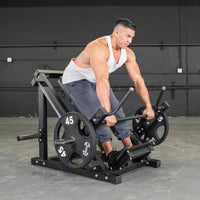 Thumbnail for Man in white tank top using a black linear bearing row machine with 45lb plates.