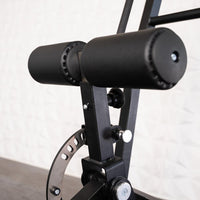 Thumbnail for Close-up of black padded rollers and adjustment mechanism on a hip thrust machine.