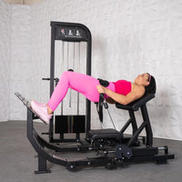Thumbnail for Woman in pink activewear performing a hip thrust exercise on a black selectorized glute drive machine.
