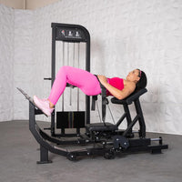 Thumbnail for Woman in pink performing hip thrusts on a black selectorized glute drive machine.