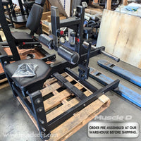 Thumbnail for Black seated calf raise machine with adjustable roller pads and foot extension, on a wooden pallet.