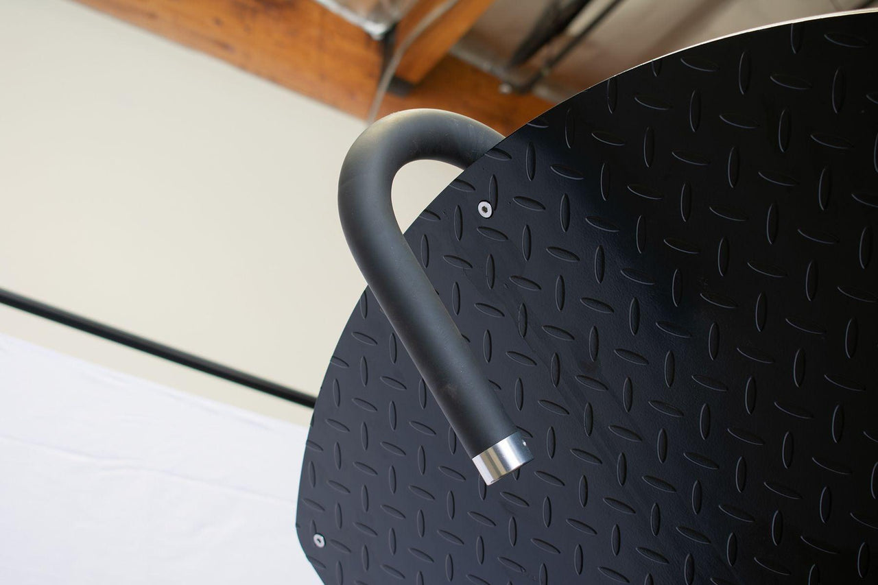 Close-up of a black textured footplate with a curved black handle and silver end cap.