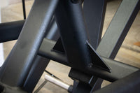 Thumbnail for Close-up of the black metal frame and welds of the leg press machine.
