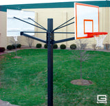 Dual basketball system with two backboards and hoops on a single black pole in a grassy yard.