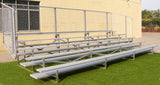Five-row aluminum bleacher with a chain-link fence on artificial turf.