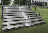 Aluminum bleachers with 8 rows, two aisles, and handrails on a grassy field.