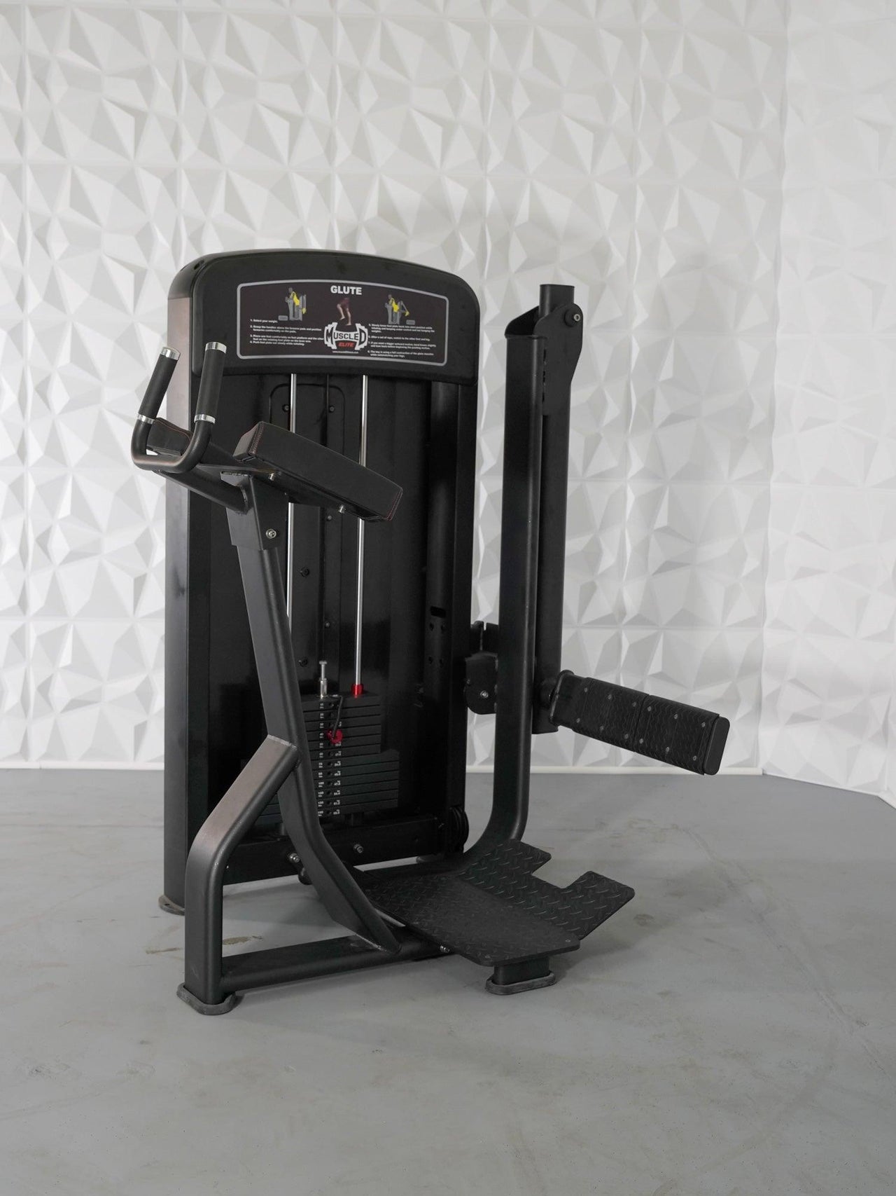 Black commercial glute machine with weight stack, footplate, and padded armrests.