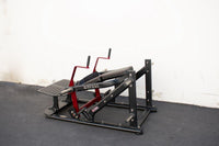 Thumbnail for Black and red plate-loaded hip thruster machine on a black gym floor against a white wall.