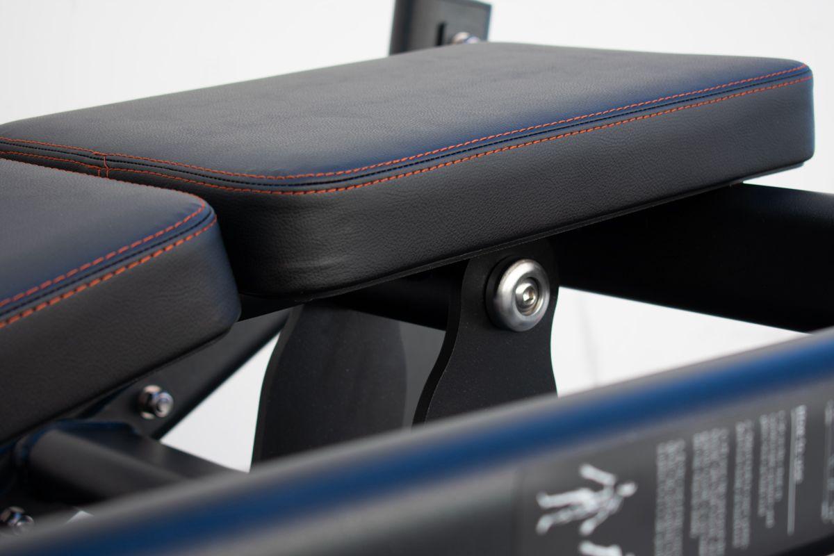 Black padded seat with red stitching on a hip thruster machine.