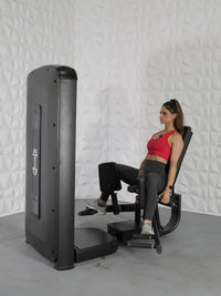 Thumbnail for Woman in red top using a black thigh adduction/abduction machine.