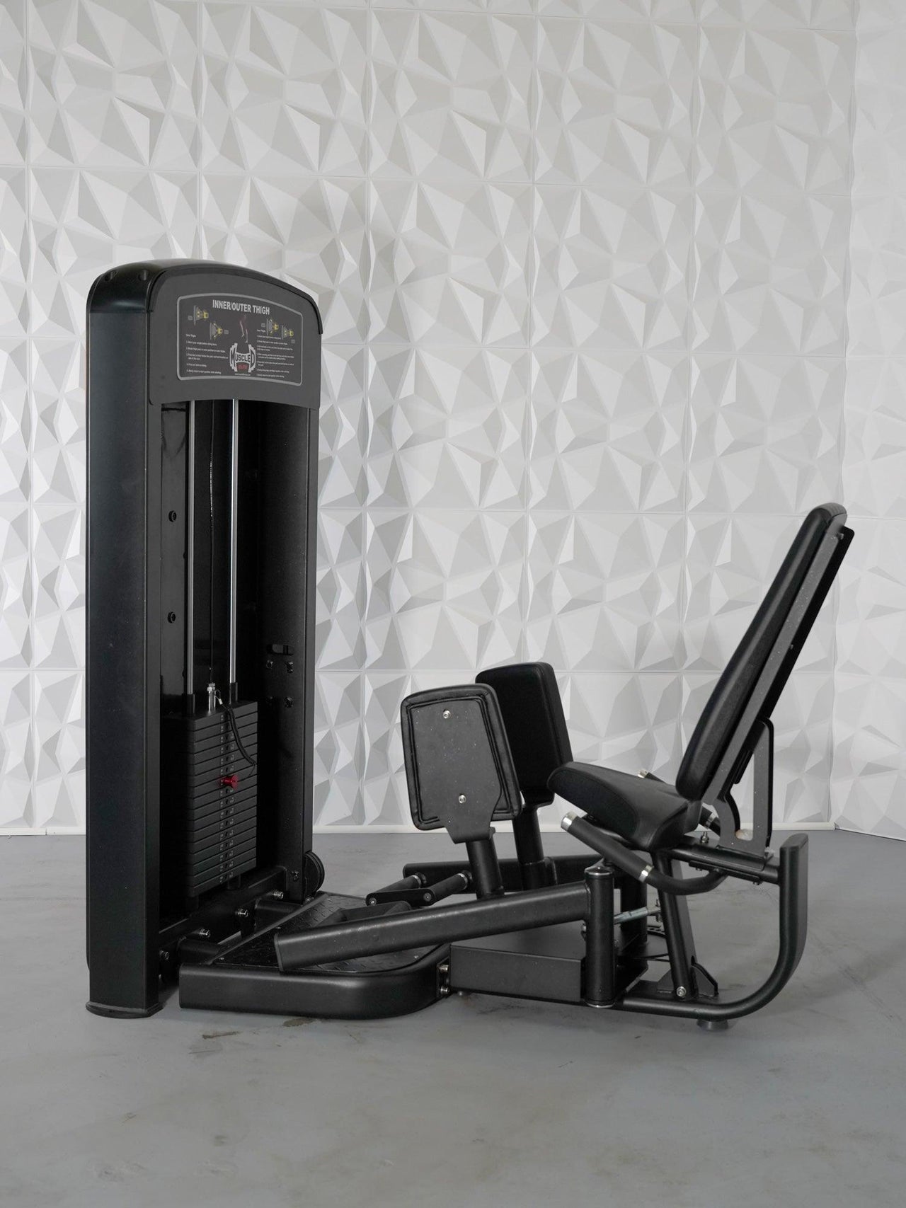 Black inner and outer thigh selectorized gym machine with adjustable seat and weight stack.