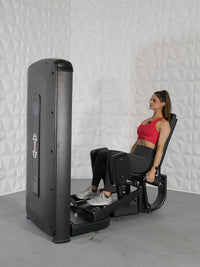 Thumbnail for Woman in red top and black leggings using a black inner and outer thigh workout machine.