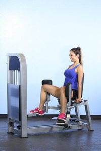 Thumbnail for Woman in blue tank top using a seated inner-outer thigh combo machine.