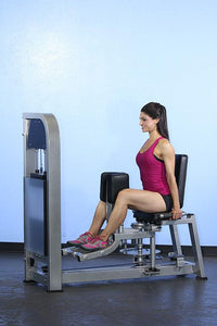 Thumbnail for Woman in pink top and black shorts using a seated inner/outer thigh machine.