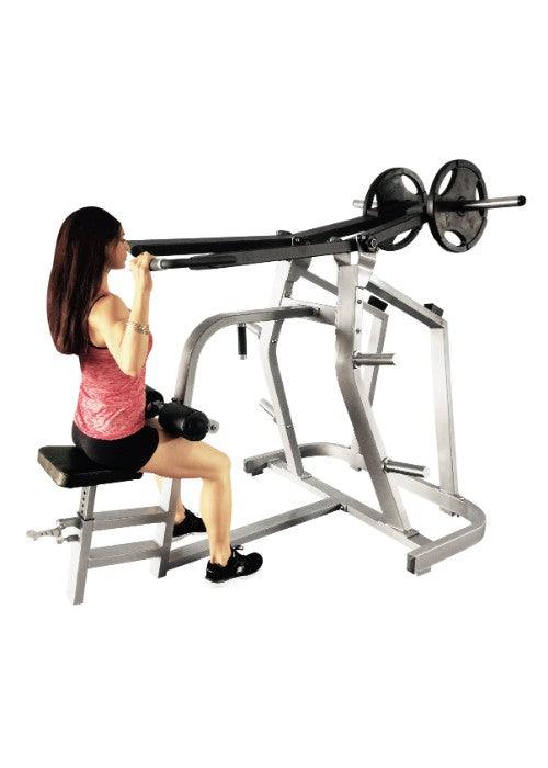 Woman using a gray lat pulldown machine with black weight plates and storage pegs.