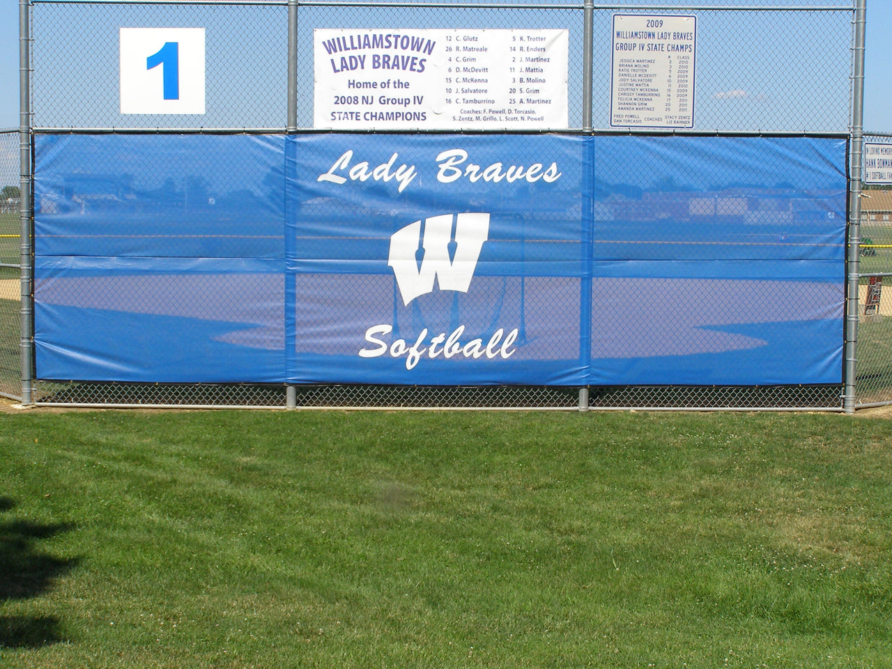 Printed windscreen directly behind home plate on a softball field