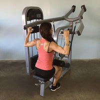 Thumbnail for Woman in a pink top using a gray lat pulldown machine.