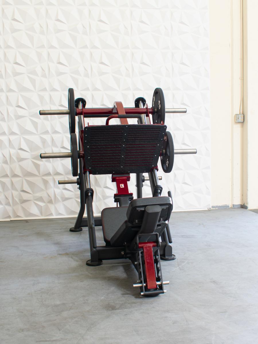Red and black plate-loaded leg press machine with an adjustable back pad.
