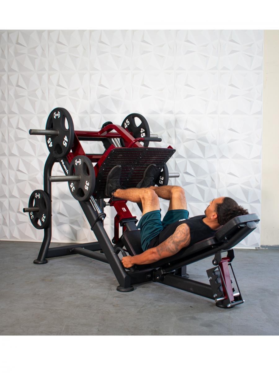 Man using a red and black plate-loaded leg press machine with 45lb and 35lb weights.