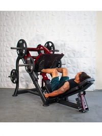 Thumbnail for Man using a red and black plate-loaded leg press machine with 45lb and 35lb weights.