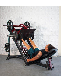 Thumbnail for Man using a black and red leg press machine with weight plates in a gym.
