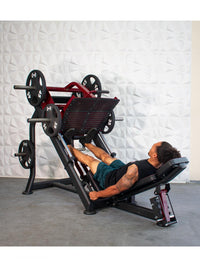 Thumbnail for Man using a red and black plate-loaded leg press machine with weights in a gym.
