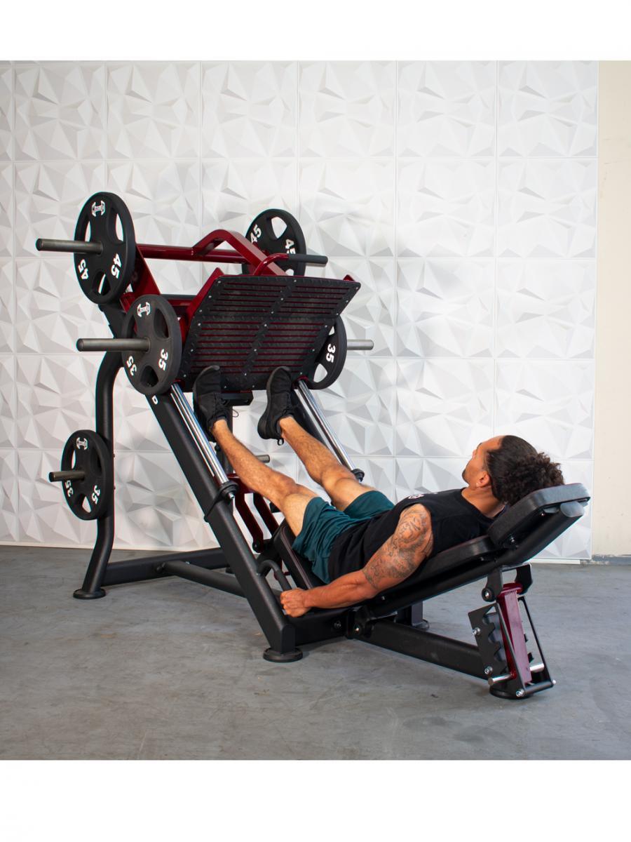 Man using a red and black plate-loaded leg press machine with 45lb and 35lb weights.