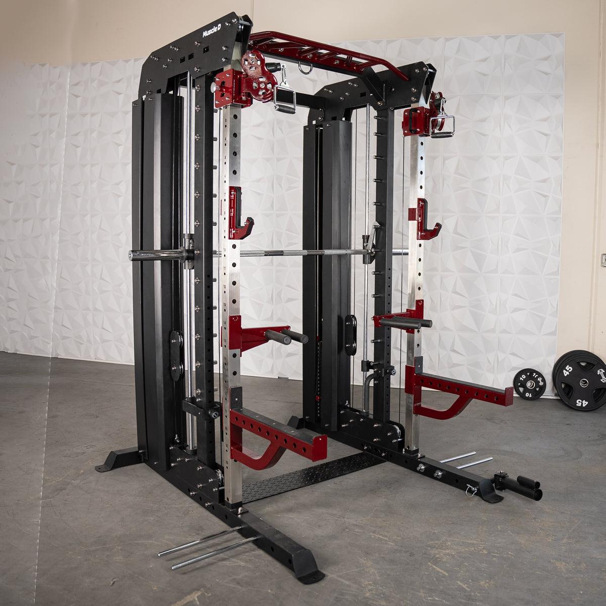 Black and red multi-functional fitness machine with a barbell, cables, and weight plates on the floor.