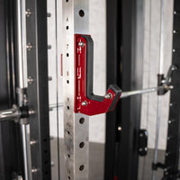 Thumbnail for Close-up of a red J-hook with black padding attached to a silver power rack upright.