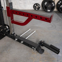Thumbnail for Red and black fitness equipment with weight plate storage, a spotter arm, and a landmine attachment.