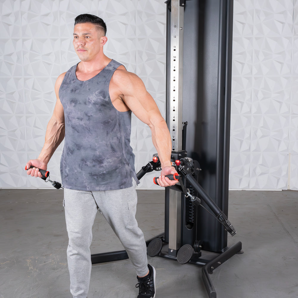 Man in a tank top using a dual adjustable functional trainer for a chest fly exercise.