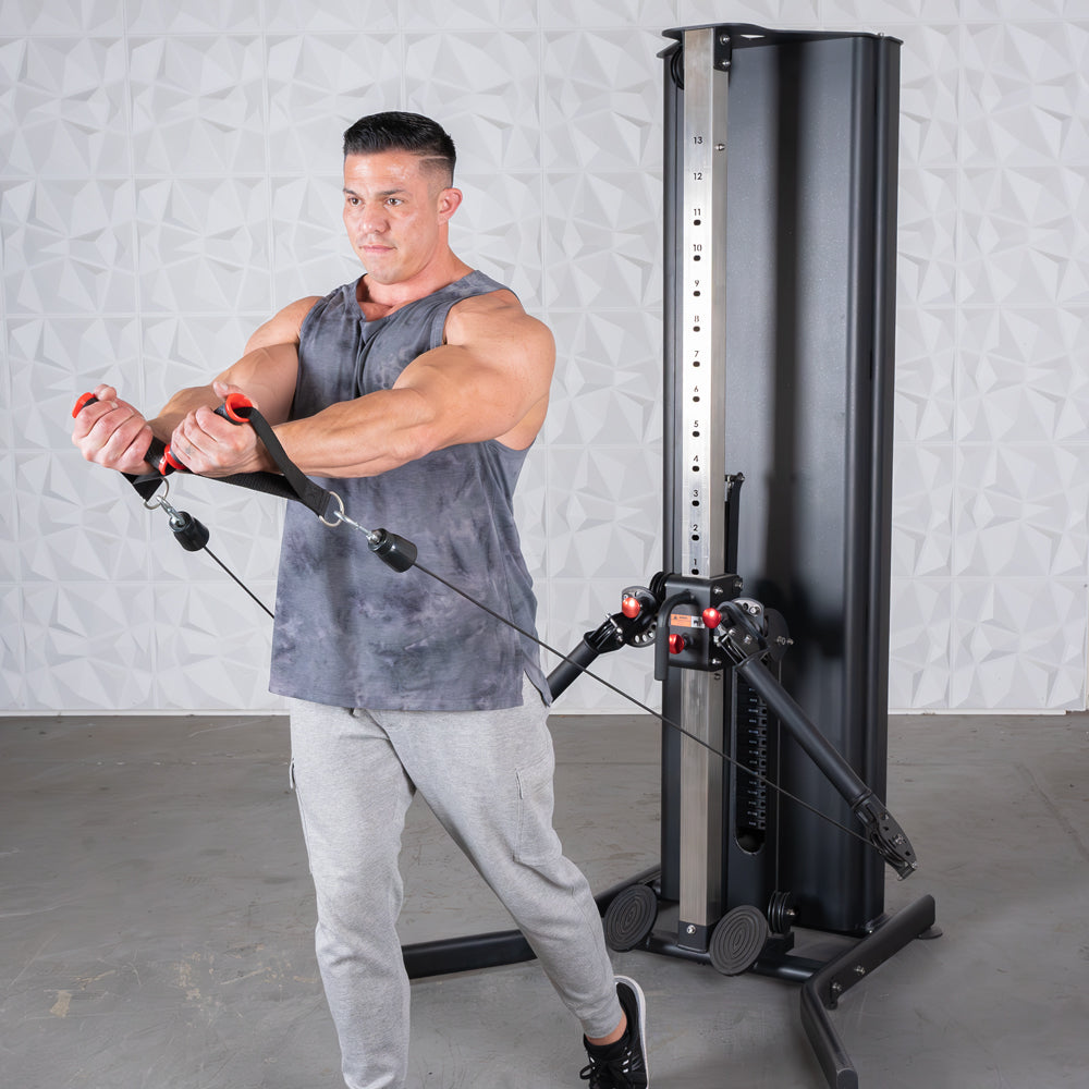 Man in tank top and sweatpants using a black dual adjustable functional trainer.