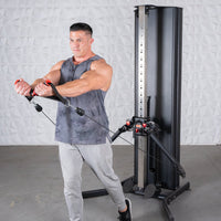 Thumbnail for Man in tank top and sweatpants using a black dual adjustable functional trainer.